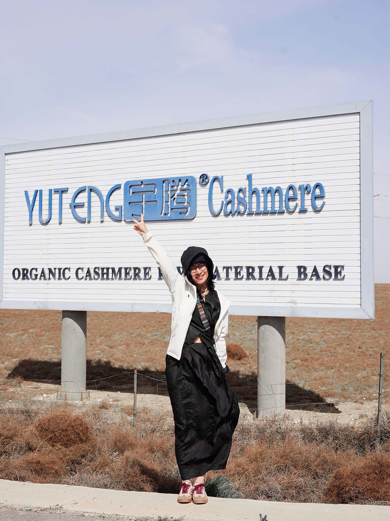 girl in front of organic cashmere farm sign 2